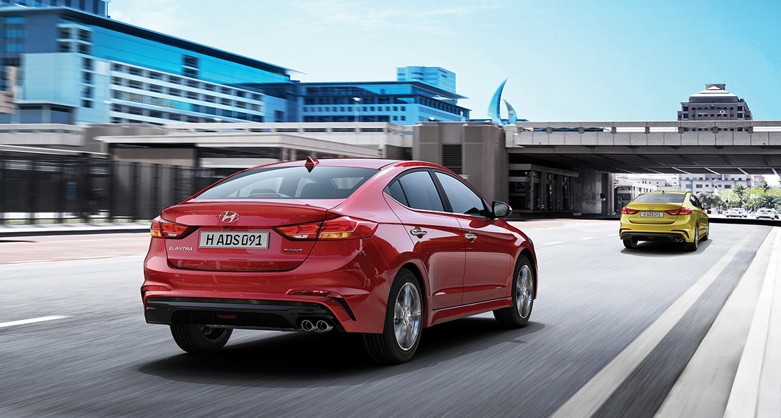 Rear view of two Elantra Sport cars driving on the road