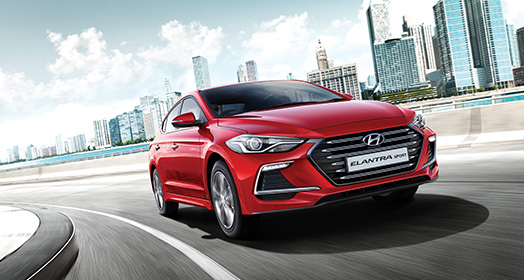 Right side front view of red Elantra Sport driving on the road