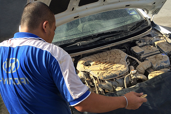 Hyundai technician inspecting a car that is damaged by the flood