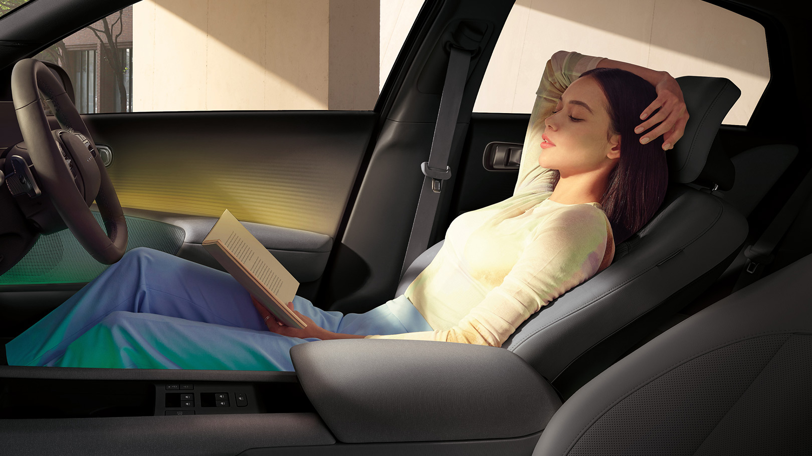 woman reading a book sitting in the front of IONIQ 6